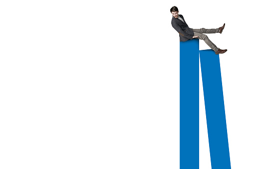 Shot of a businessman balancing on top of a graph against a white background