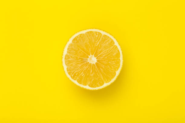 istock Lemon slice on a yellow minimal background. Bright juicy lemon on a yellow blank isolated background. Summer, sun, health concept. 1297197286