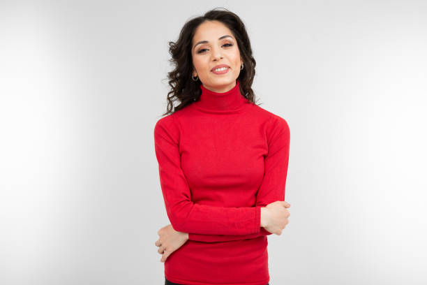 istock serious brunette girl in a red sweater posing on a white studio background 1297198458