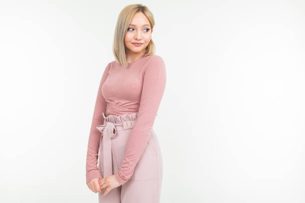 istock young attractive woman in pink clothes posing on white background with copy space 1297198566
