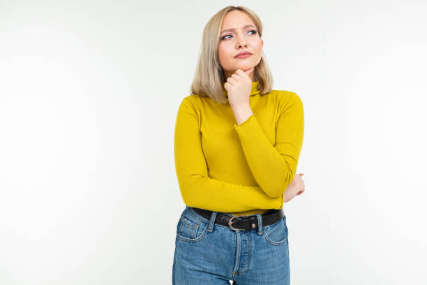 istock girl in a yellow blouse and jeans thought on a white studio background 1297198601