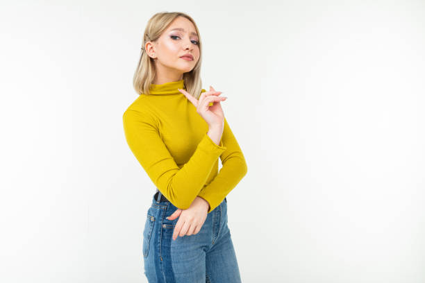 sexy blonde young woman in tight lemon blouse and jeans threatens with index finger on a white background - persuasion facial expression smiling head and shoulders imagens e fotografias de stock