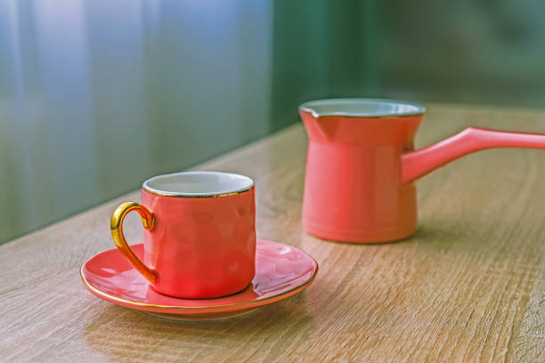 istock Pink ceramic coffee set - turk and cup on wooden table 1297198810