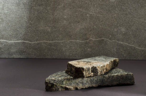 istock Closeup of grey marble pieces against bright marble wall.Empty space.Template for product presentation 1297198924