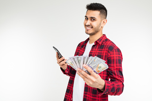 joyful adorable brunette man won the lottery and received a cash prize on a white background with copy space.