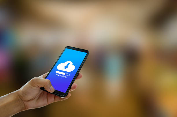 istock Hand holding smartphone with icons concept. Download  network concept. 1297200720