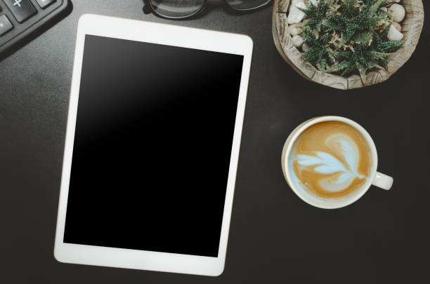 istock Topview tablet calculator and coffee cup Cactus on the desk 1297200765