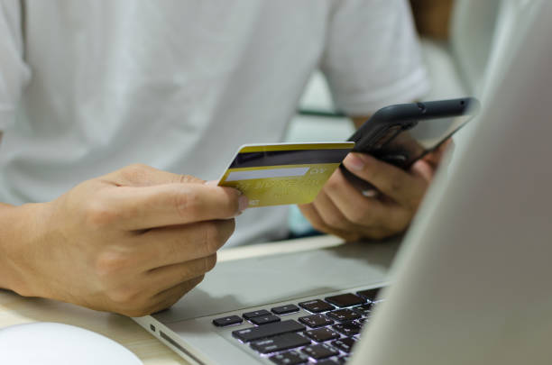 istock Man Shopping Online Using Laptop With Credit Card 1297200782
