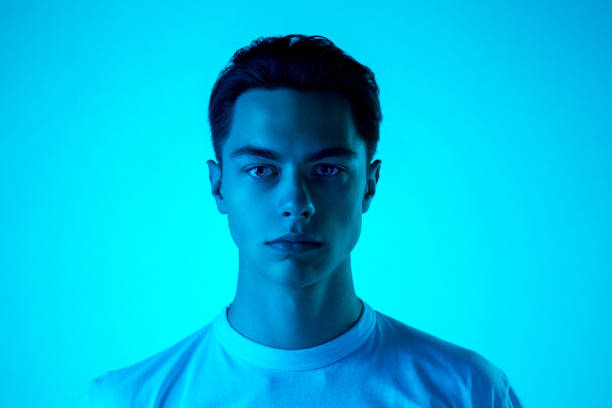 istock Handsome caucasian man's portrait isolated on blue studio background in neon light, monochrome 1297201812