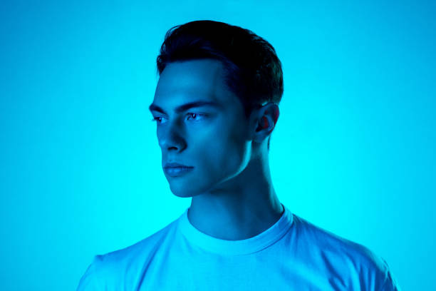 istock Handsome caucasian man's portrait isolated on blue studio background in neon light, monochrome 1297201815