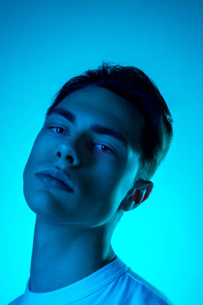 istock Handsome caucasian man's portrait isolated on blue studio background in neon light, monochrome 1297201818