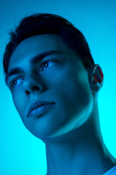 istock Handsome caucasian man's portrait isolated on blue studio background in neon light, monochrome 1297201839