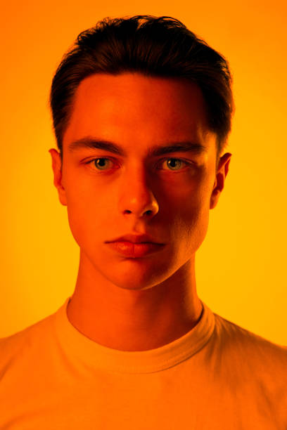istock Handsome caucasian man's portrait isolated on orange studio background in neon light, monochrome 1297201913