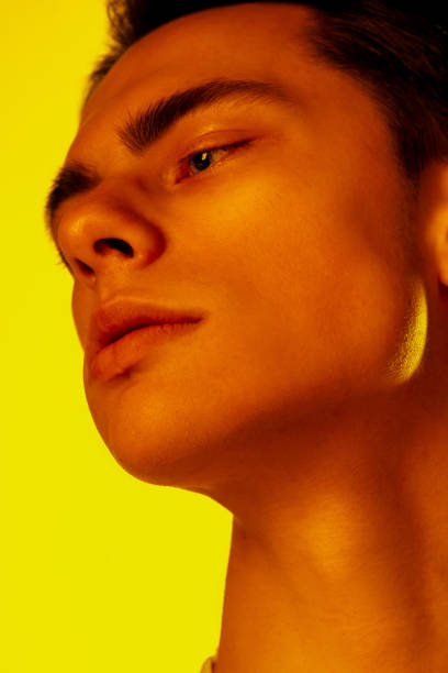 istock Handsome caucasian man's portrait isolated on orange studio background in neon light, monochrome 1297201918