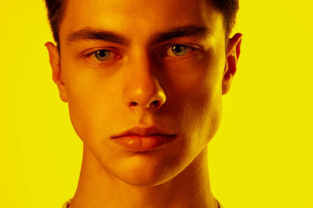 istock Handsome caucasian man's portrait isolated on orange studio background in neon light, monochrome 1297201919