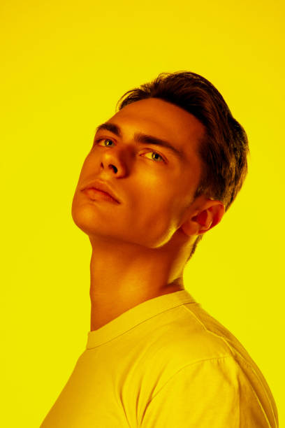 istock Handsome caucasian man's portrait isolated on orange studio background in neon light, monochrome 1297201921