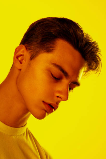 istock Handsome caucasian man's portrait isolated on orange studio background in neon light, monochrome 1297201925