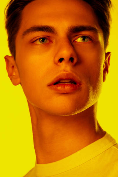 istock Handsome caucasian man's portrait isolated on orange studio background in neon light, monochrome 1297201929