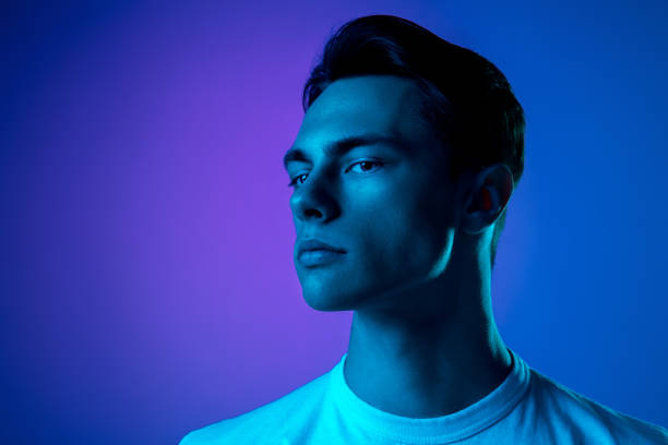 Handsome caucasian man's portrait isolated on purple studio background in neon light, monochrome Icon. Handsome caucasian man's portrait isolated on purple studio background in neon, monochrome. Beautiful male model. Concept of human emotions, facial expression, sales, ad, fashion and beauty. artists model photos stock pictures, royalty-free photos & images
