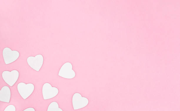 istock White hearts on pink background 1297202254