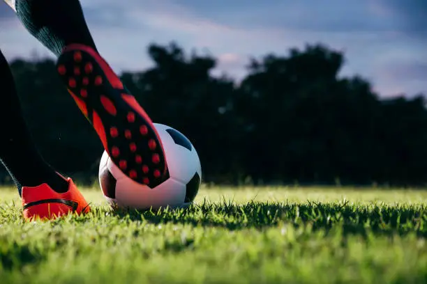 Football player kicking to soccer ball at free kick point.