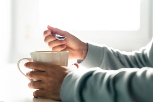 istock Person drinking a cup of coffee with a spoon 1297203778