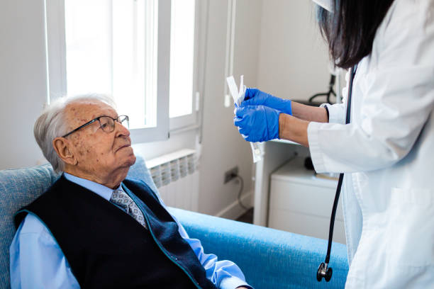 istock Nurse performing a coronavirus pcr test on an elderly man in his home 1297204381