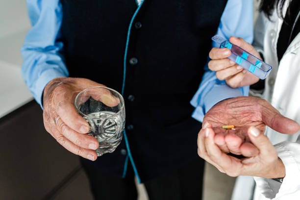 istock Nurse giving pills to an elderly person's hands 1297204508