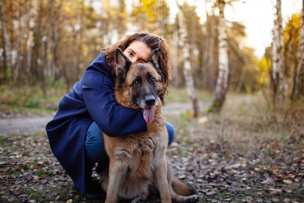 Young Woman Hugging her German Shepherd in the Park