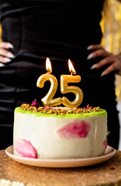 istock Golden lit candles 25 on birthday cake 1297205275