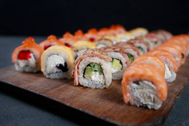 istock Seafood delicatessen sushi rolls set on board. 1297206719