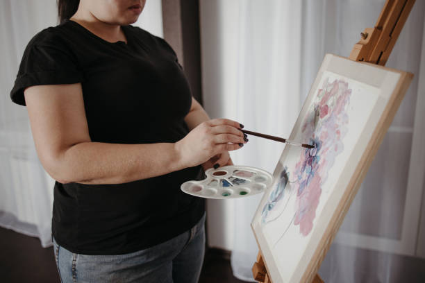 istock Young concentrated woman do easel drawing 1297206811