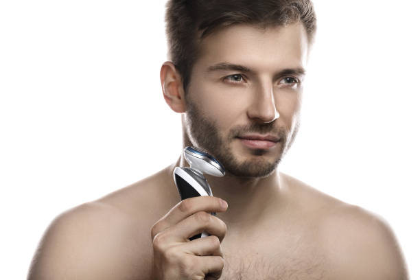 istock Handsome man is using electric shaver on white background 1297207023