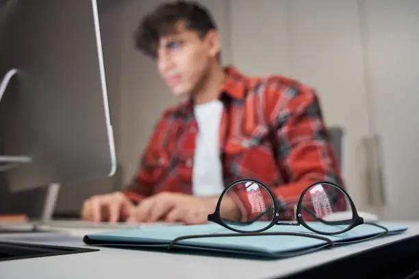 Photo of Male designer sitting in front of the imac computer