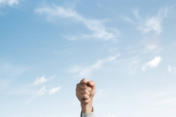 istock A fist raised. The sky in the background. 1297209746
