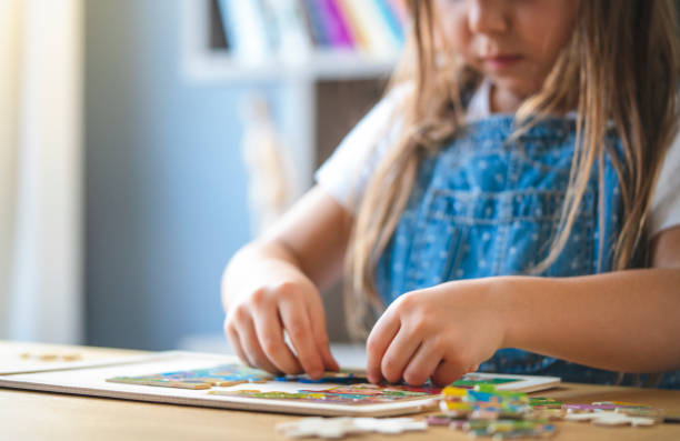 istock Little girl playing with puzzles at home 1297210112
