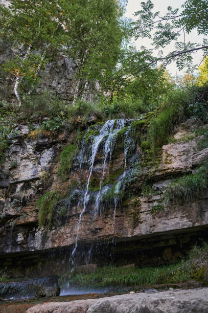 istock view of a small mountain river waterfall among large cobblestones from a cliff. 1297210559