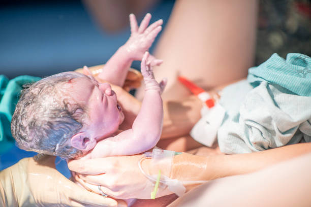 A baby being born at the delivery room at the hospital.