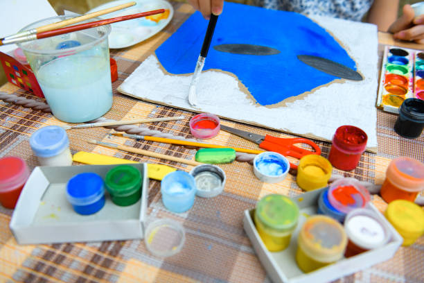 istock a girl drawing blue gouache cardboard, artistic creation at home, makes creative artwork 1297211373