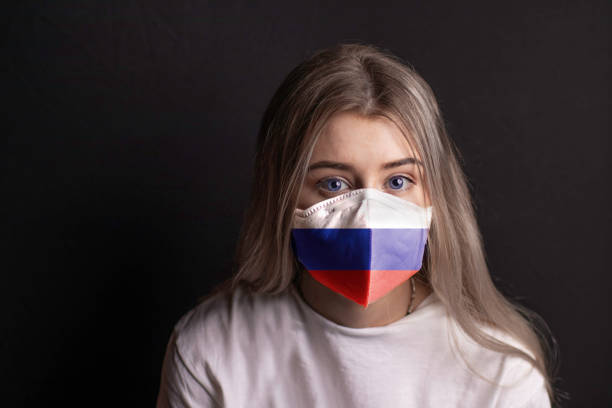 bella giovane donna bionda con i capelli lunghi in una maschera russa. girato su uno sfondo nero - russian shot foto e immagini stock