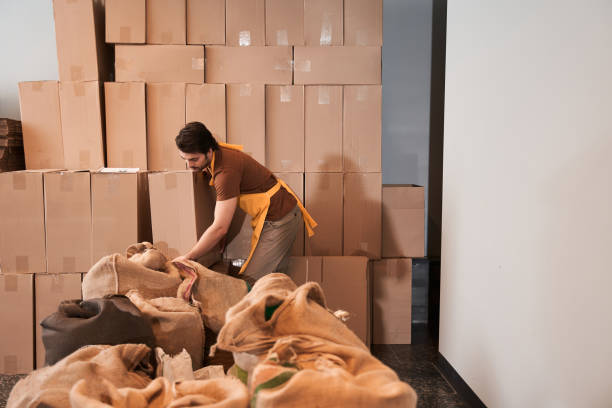 istock Man preparing to putting packages with roasted coffee into big box 1297212790