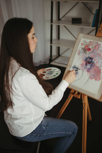 istock Young concentrated woman do easel drawing 1297213323