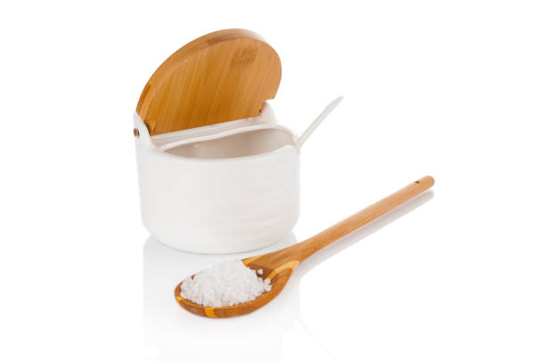 sea salt in wooden spoon and ceramic salt container isolated on white background - healthcare and medicine iodine salt isolated on white imagens e fotografias de stock