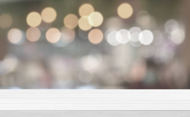 istock Empty white wood tabletop, desk over blur soft light in restaurant bokeh background 1297215869