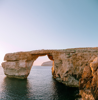 Azure window of the Gozo island - lime rock in a shape of arch (window) standing in the sea. Blue cloudless sky is on the background.