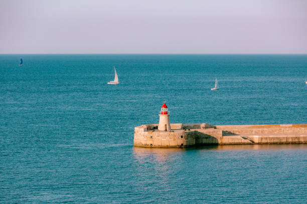 istock lighthouse at sea in sunset. Valetta, Malta. 1297215950