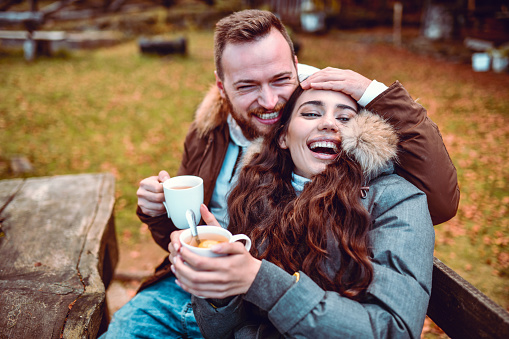 Smiling Couple Enjoying Embracing, Tea And Love During Forest Vacation