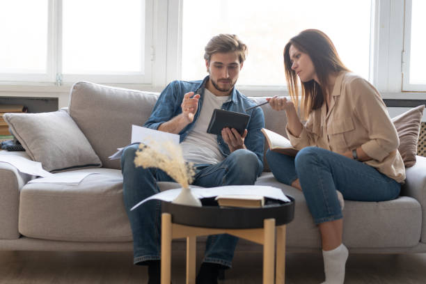 istock Photo of cheerful young couple analyzing their finances with documents 1297217333