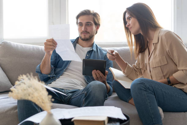 istock Photo of cheerful young couple analyzing their finances with documents 1297217335