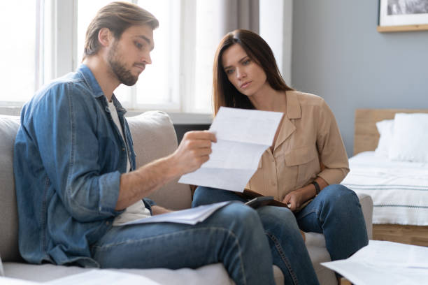 istock Photo of cheerful young couple analyzing their finances with documents 1297217343